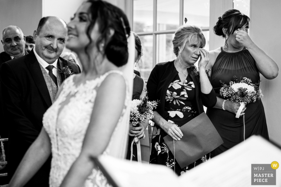 Image en noir et blanc de la mère de la mariée et demoiselle d'honneur essuyant ses larmes lors de la cérémonie à Iscoyd Park au Royaume-Uni Image en noir et blanc de la mère de la mariée et demoiselle d'honneur essuyant ses larmes lors de la cérémonie à Iscoyd Park au Royaume-Uni