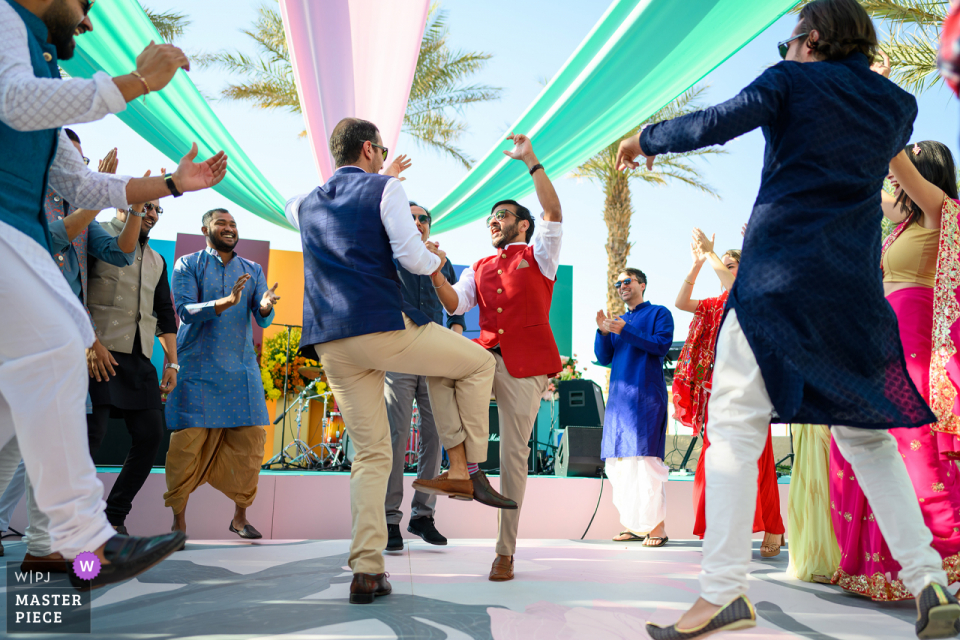 Un divertente esempio di fotografia di matrimonio documentario ad Abu Dhabi di Qasr Al Sarab che mostra la danza dei Groomsmen