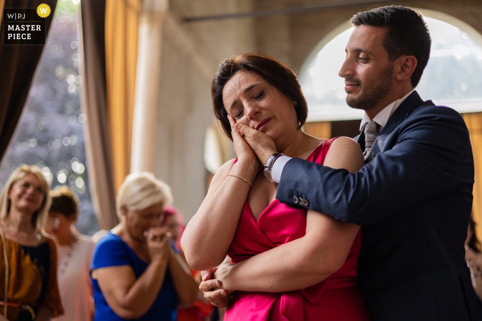 Fotografie im Dokumentarstil von einer italienischen Hochzeit in der Villa Foscarini Stra, die einen emotionalen Moment zwischen dem Bräutigam und seiner Mutter festhält Fotografie im Dokumentarstil von einer italienischen Hochzeit in der Villa Foscarini Stra, die einen emotionalen Moment zwischen dem Bräutigam und seiner Mutter festhält