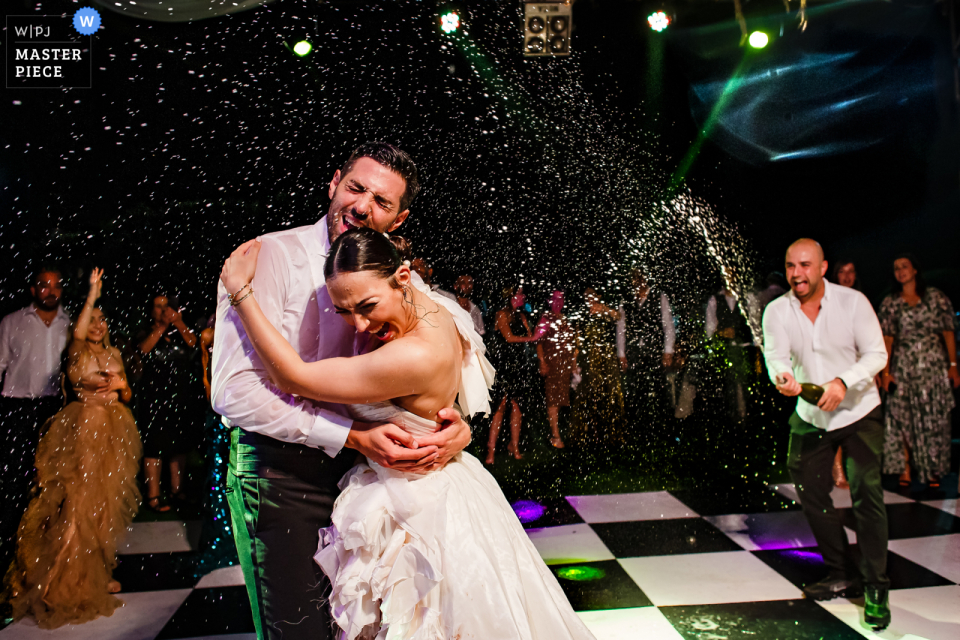 Na primeira dança do casal em pista quadriculada, os convidados comemoraram com um pouco de champanhe Os convidados comemoraram o dia especial do casal com uma dança animada no piso xadrez encharcado de champanhe do Korineum Golf and Beach Resort em Kyrenia, Chipre