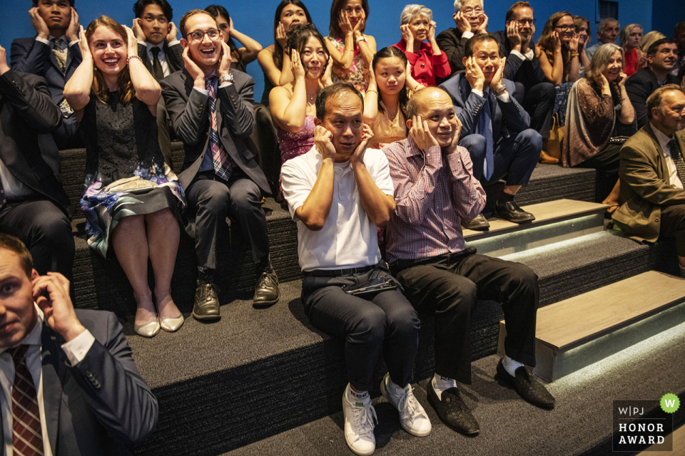 Boston Museum Wedding: Guests Cover Ears During Pre-Ceremony Electrical Show At the Museum of Science in Boston, Massachusetts, guests cover their ears during a loud electrical show happening just before the wedding ceremony, adding an unexpected and memorable twist to the day's events.