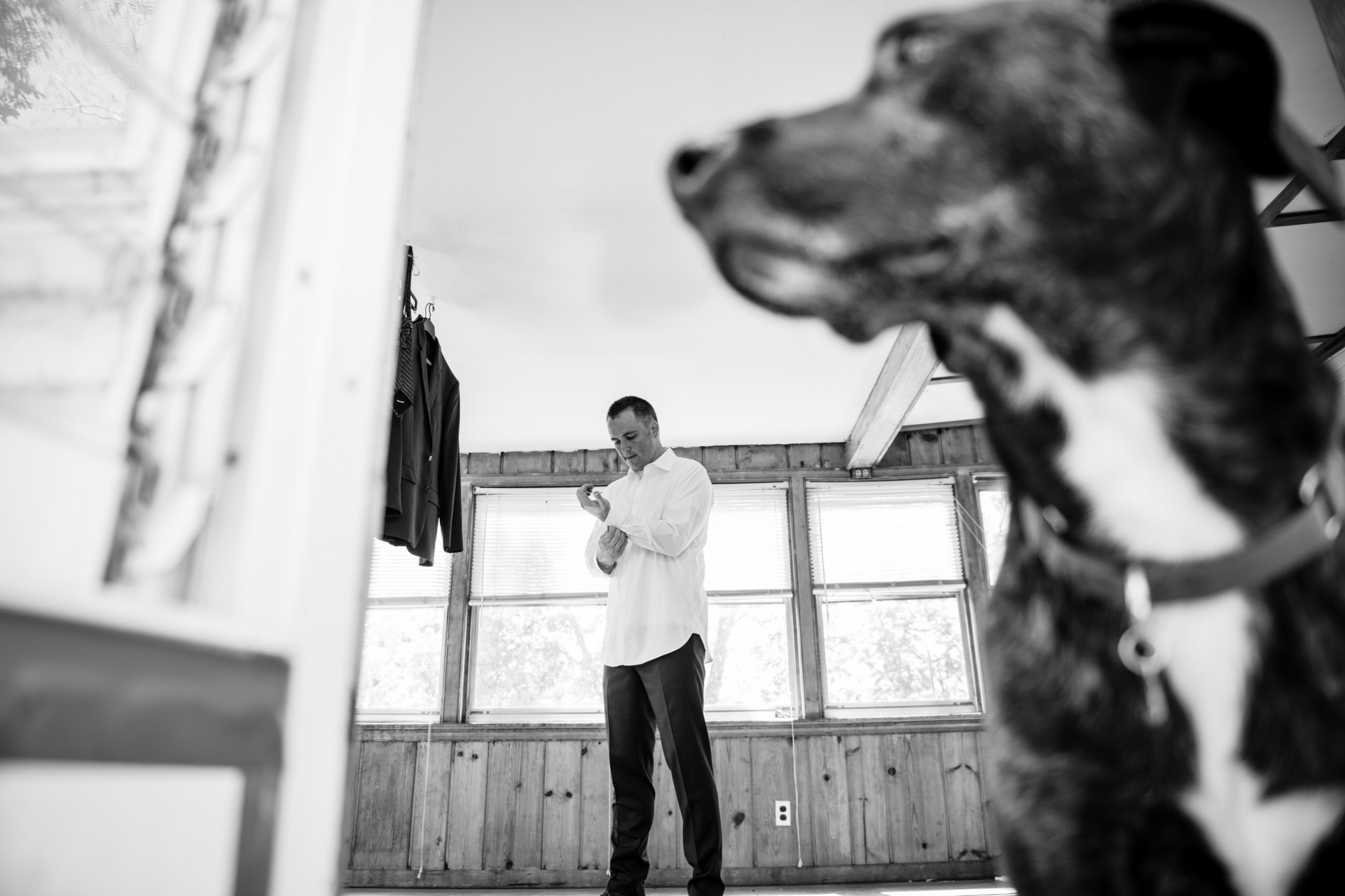 Photographe MD Elopement - marié et chien se préparant pour le mariage Photo de mariage à domicile au Maryland | le marié se prépare avec chiot