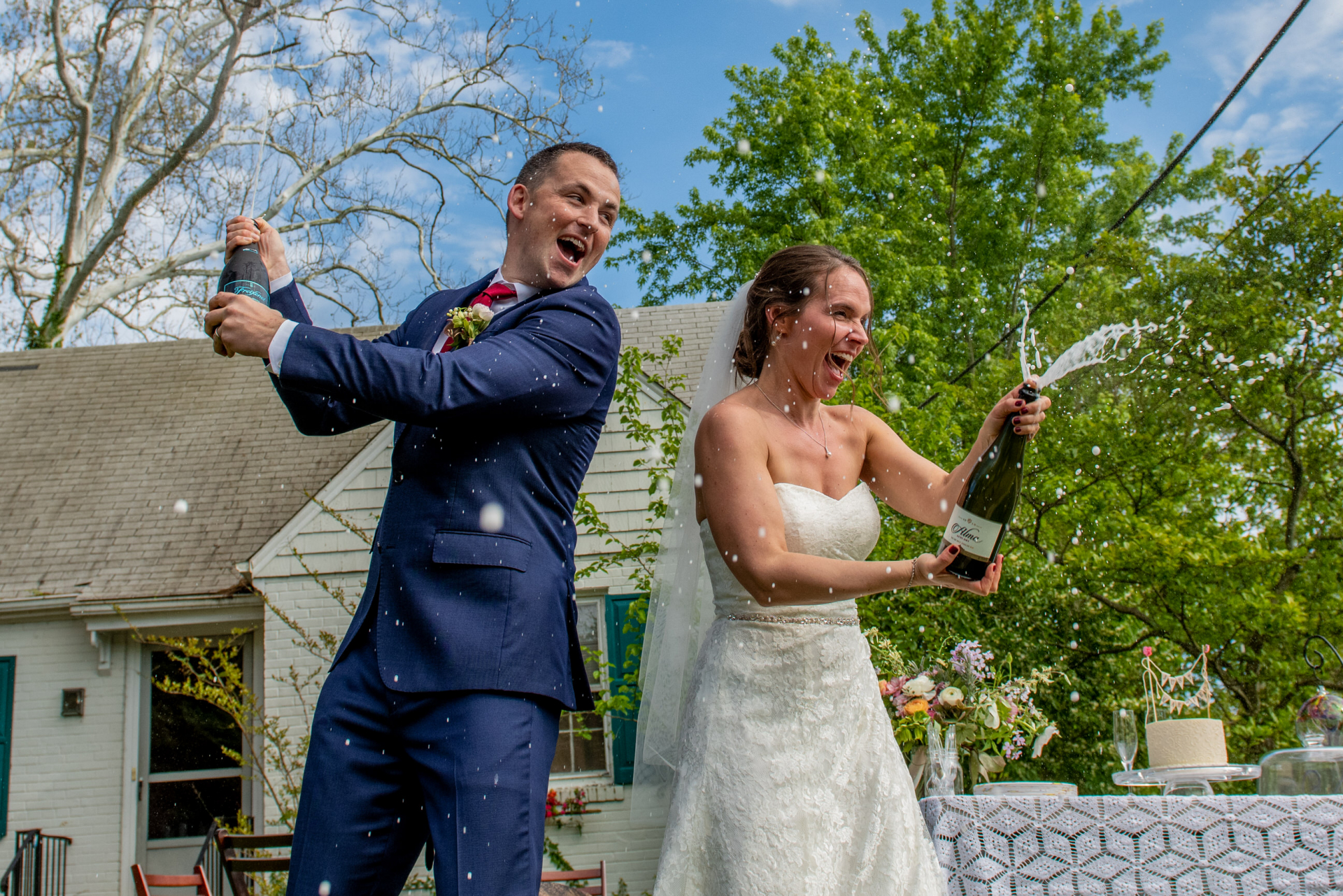 MD Elopement Couple Image - le marié avait dit qu'il avait toujours voulu secouer une bouteille de champagne le jour de leur mariage Photos de Elopement extérieur Maryland | Après la cérémonie, la mariée et le marié ont invité leurs voisins à partager de délicieux gâteaux et champagne