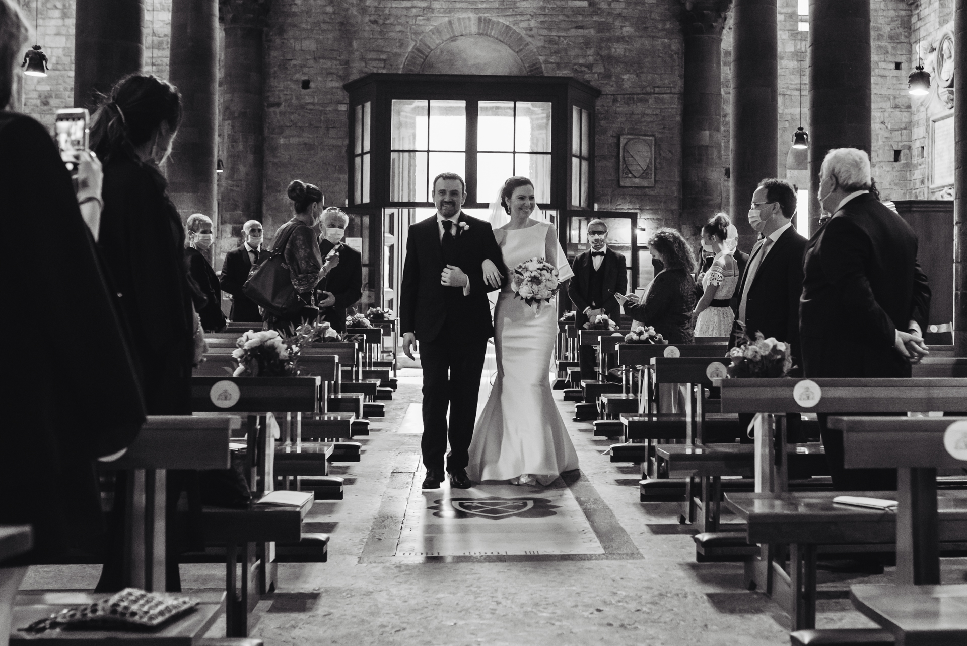 Florence Wedding Ceremony Image - all of their guests rise to greet them as the couple walks down the aisle arm-in-arm Florence, Piazza del Limbo Elopement Ceremony Photography | The bride and groom enter the ceremony in Piazza del Limbo together