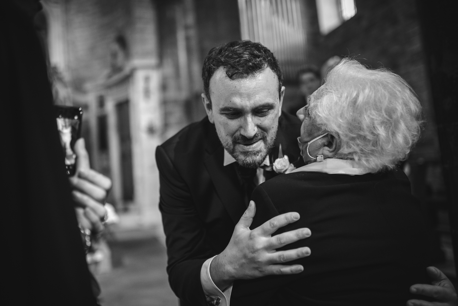 Italy Wedding Ceremony Images - the groom gives one of the guests a big hug Tuscany Elopement Photographer | The guests are all eager to share their love and emotions with the couple