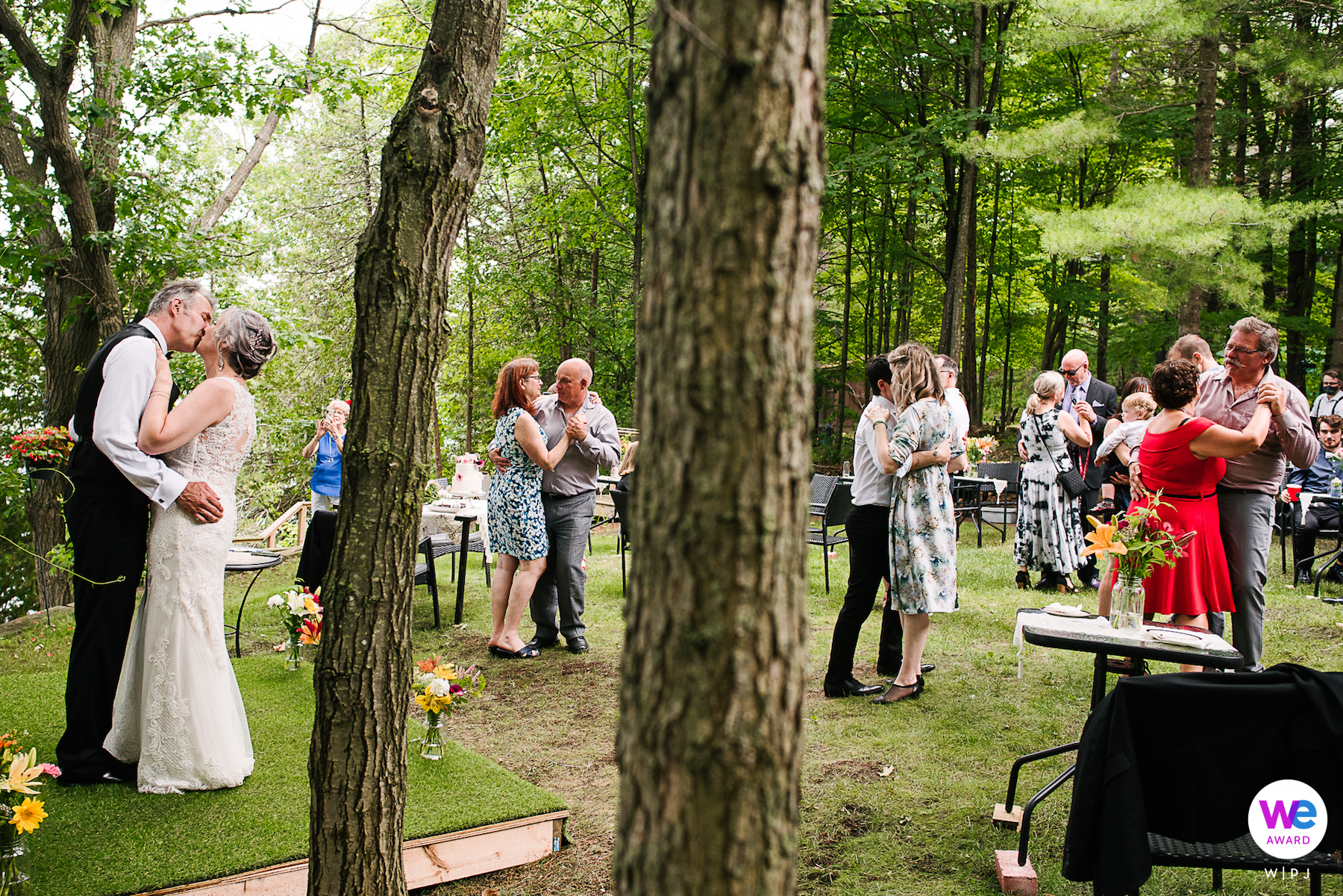 La novia y el novio bailaron, con su familia uniéndose a ellos en un baile lento en el patio trasero para celebrar su pequeña e íntima boda al aire libre.