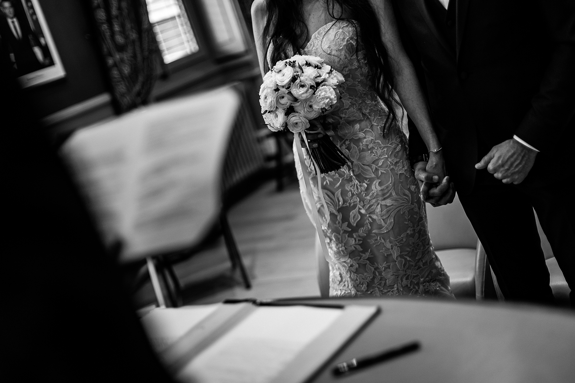 France Civil Elopement Pic in B/W - They hug each other and intertwine their fingers Lyon Town Hall, FR Wedding Ceremony Photographer | The mayor reads the consent of the bride and groom