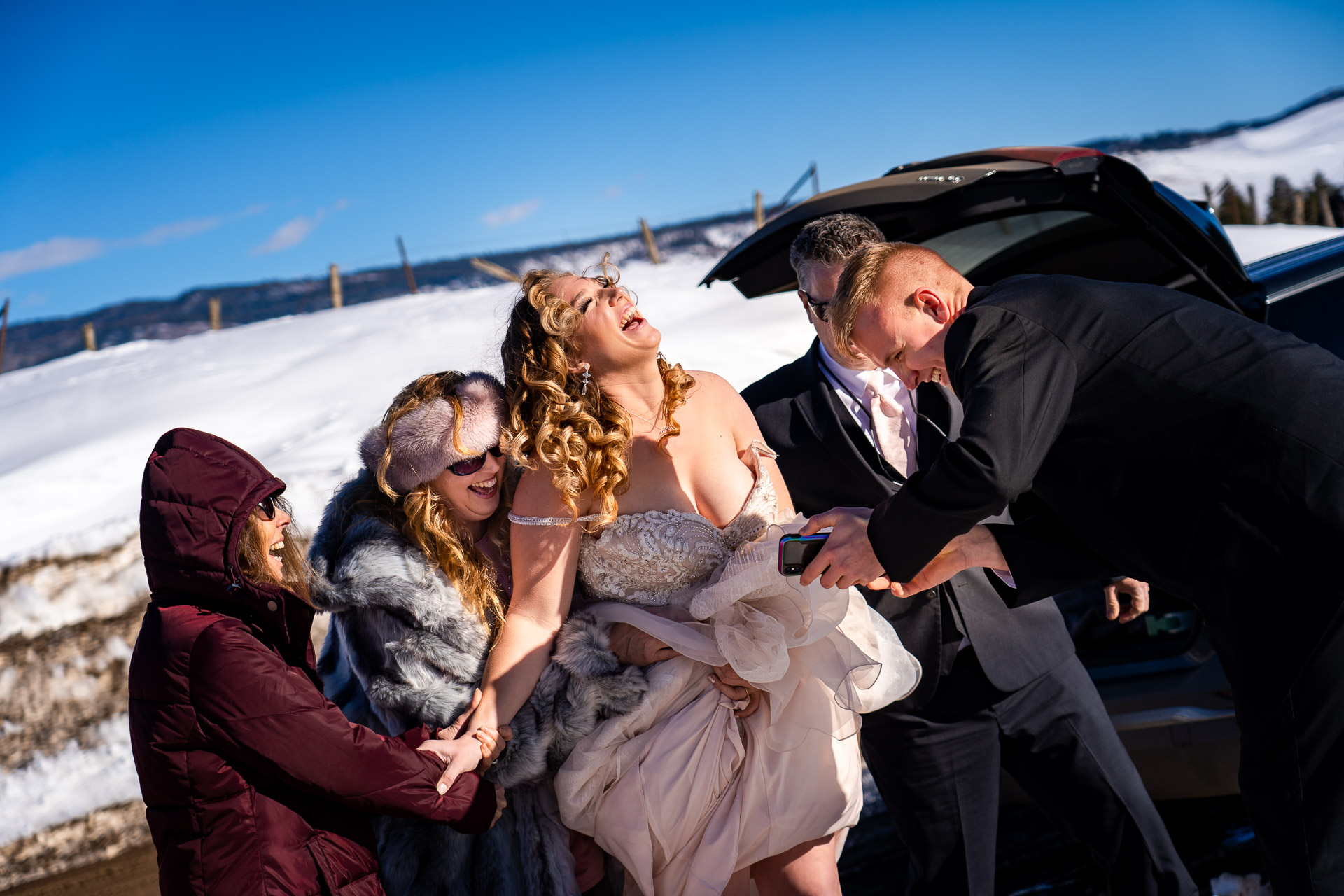 Colorado Winter Destination Elopement Pictures - Regarder des clips vidéo amusants d'un premier tour de vue Piedra Canyon Overlook Photographie de mariage | La mariée rit après avoir regardé une vidéo qui montrait le marié surpris de voir son frère