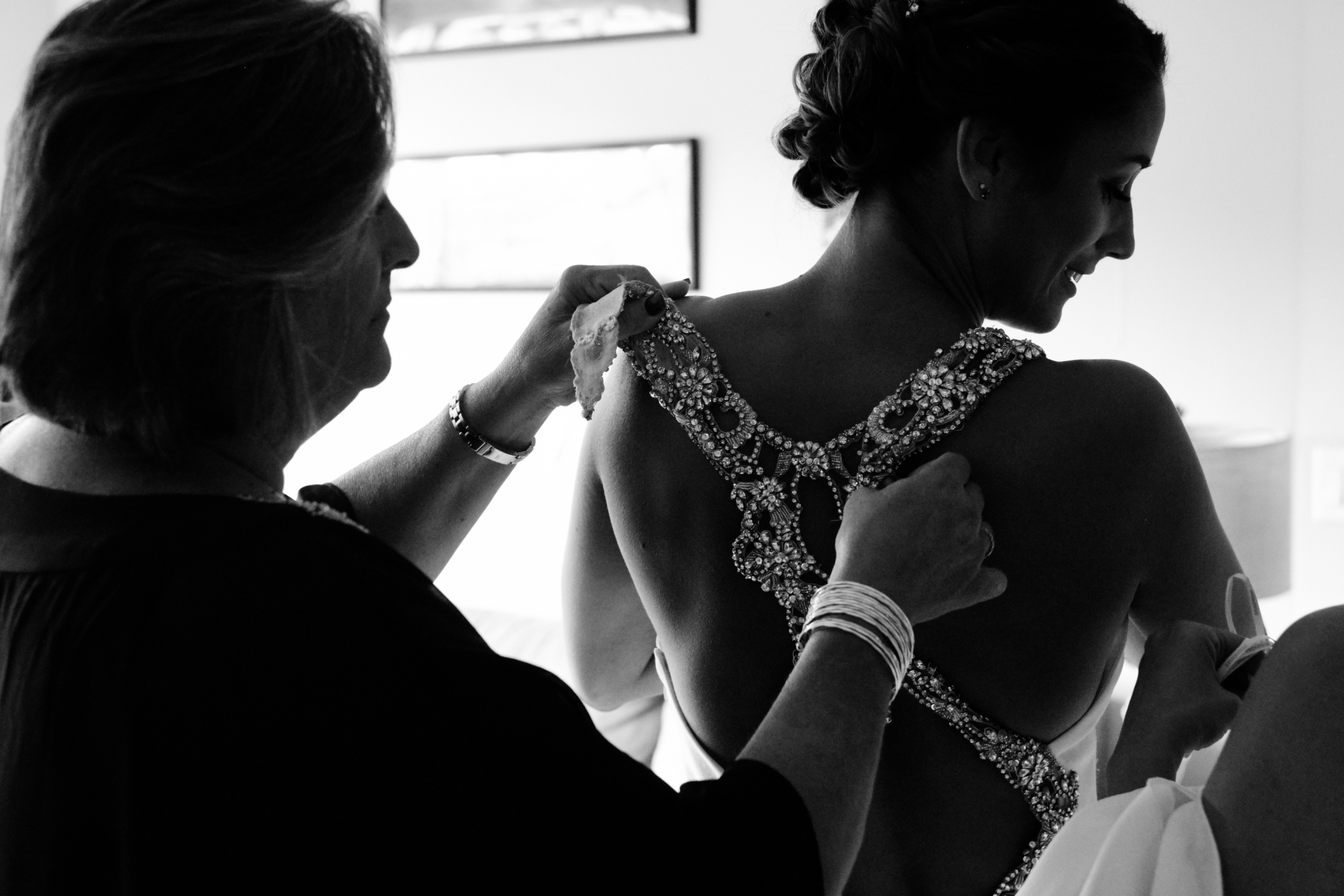 PA Elopement Image in BW - Strip District neighborhood bride getting ready Energy Innovation Center Wedding Venue - Pittsburgh, Pennsylvania Photos | The brides mom helps fasten the back of her dress