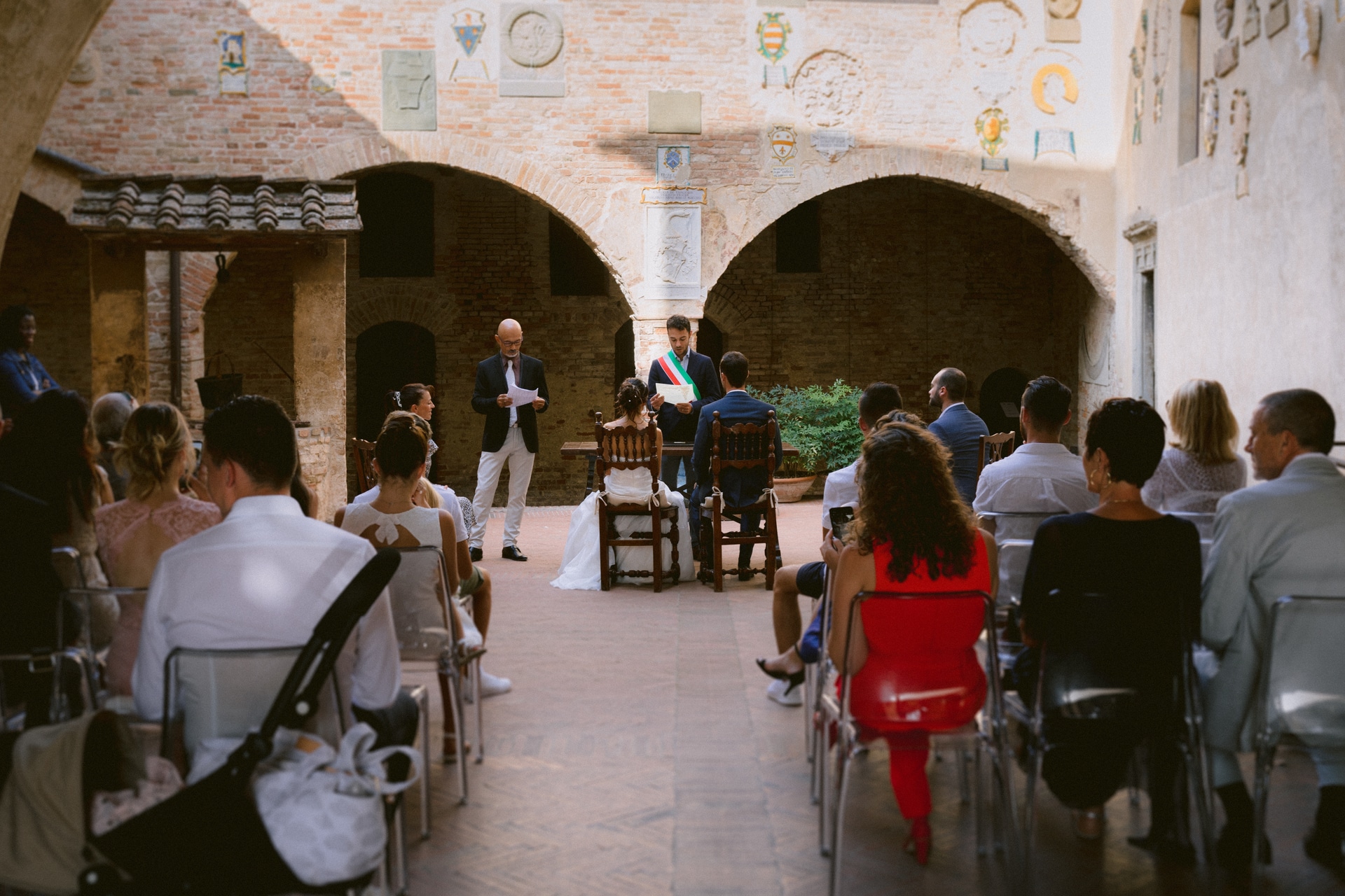 S'enfuir en Toscane pour un mariage italien à Certaldo - Image de la cérémonie de mariage Palazzo Pretorio de la mariée et du marié à l'autel Photographe de reportage de mariage en Toscane | l'atmosphère rustique du lieu de la cérémonie de mariage
