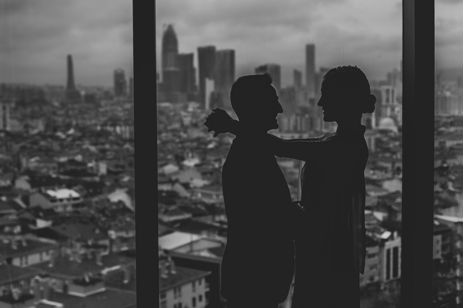 The bride and groom share an intimate moment silhouetted against the Istanbul skyline The bride and groom share an intimate moment against the Istanbul skyline at The Address Hotel, Üsküdar