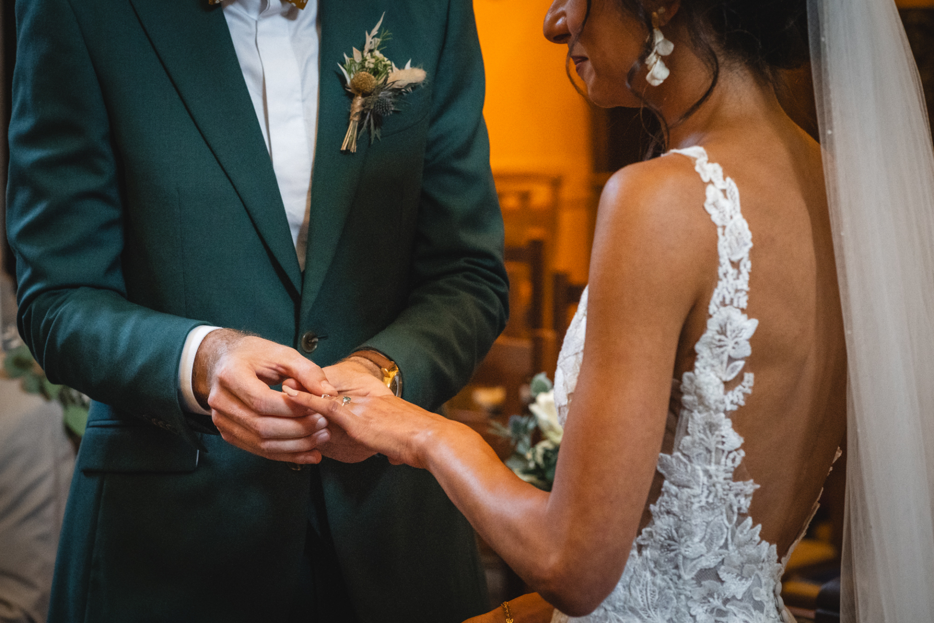 The groom slipping a wedding ring on his bride's finger at a beautiful church in Lille.