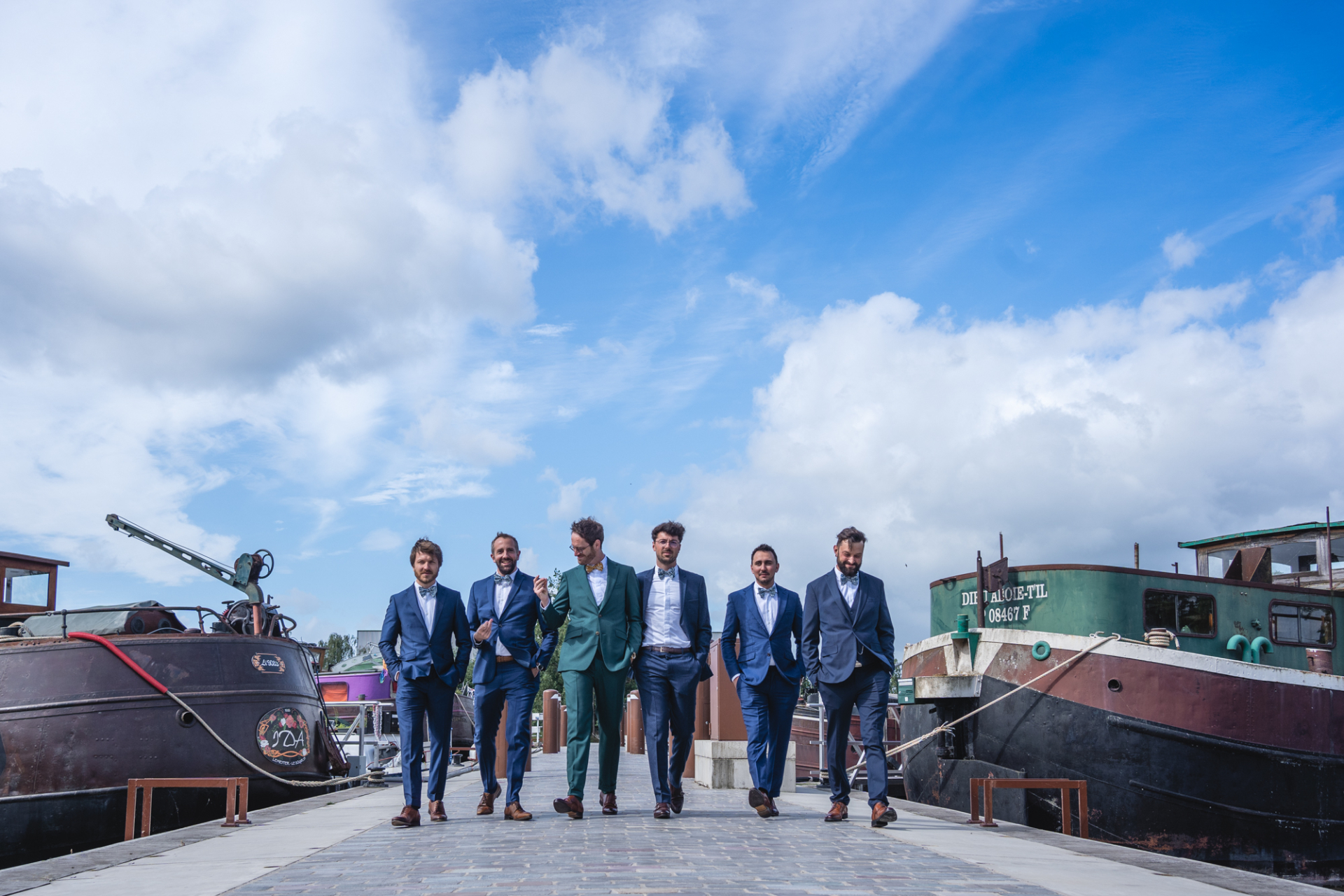 The groom and his groomsmen at Gare d'eau des Bois-Blancs port, with boats and a stunning blue sky as the backdrop.