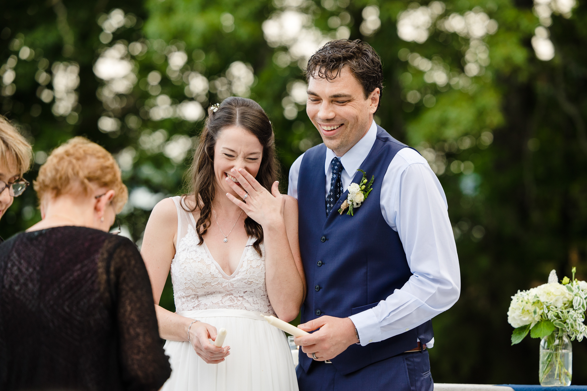 Bride and groom laugh together during candle-lighting ceremony at Smith Mountain Lake.
