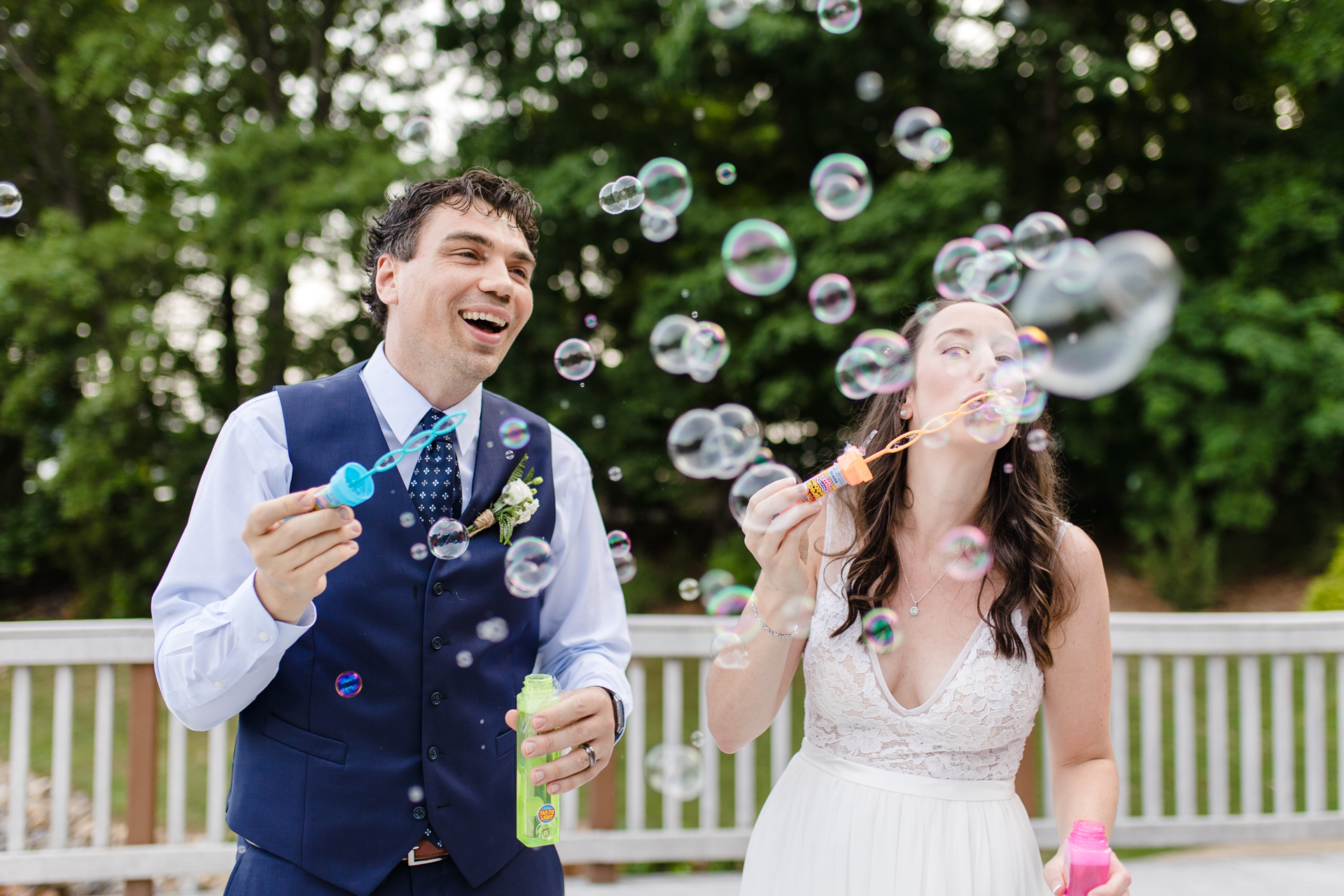 Newlyweds joyfully blow bubbles after exchanging vows at Smith Mountain Lake elopement.