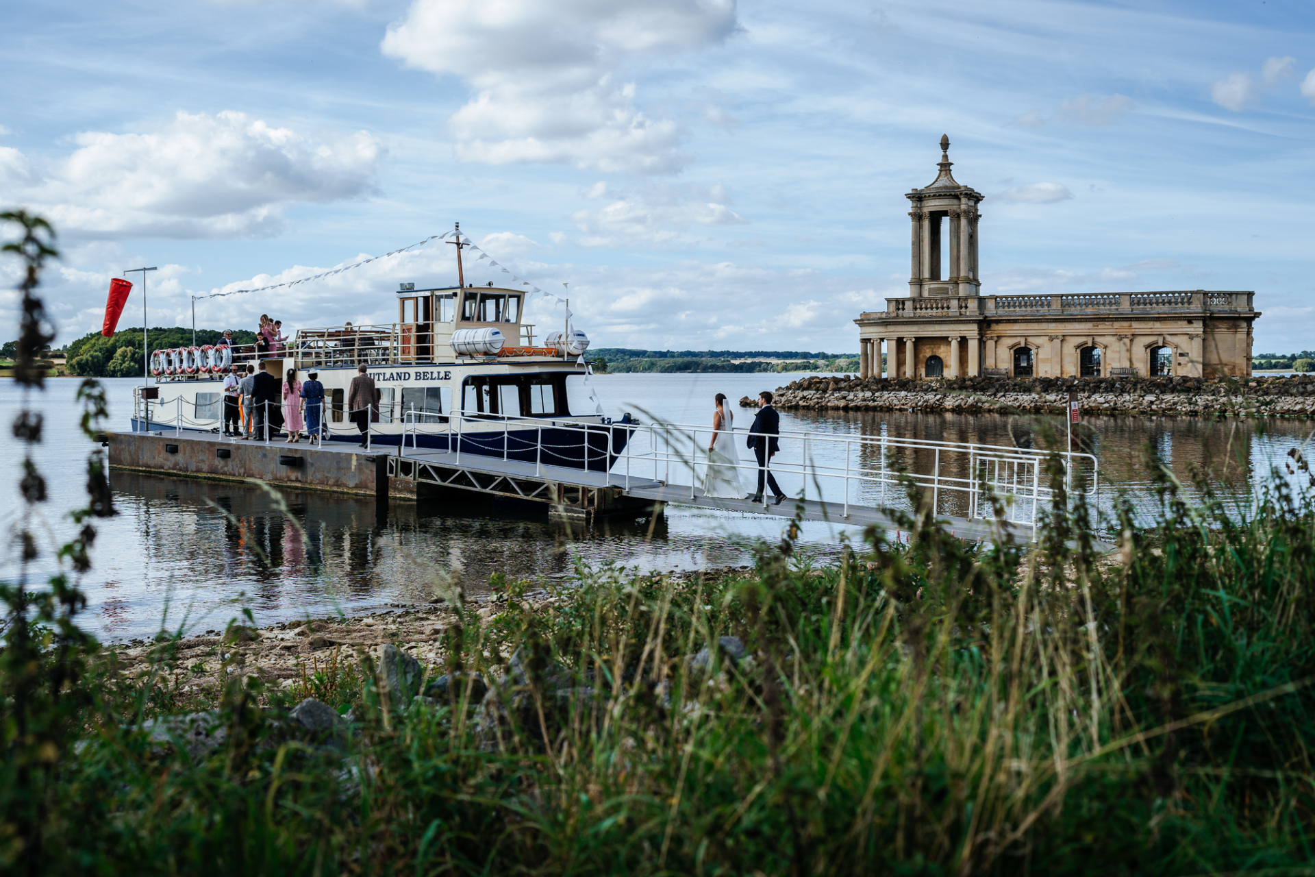 Bridal party boards Rutland Belle for reception, with Normanton Church visible in the background.