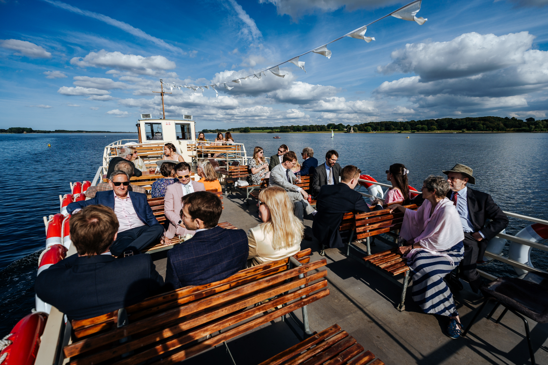 Wedding party enjoys Rutland Belle ferry cruise on Rutland Water, surrounded by scenic views.