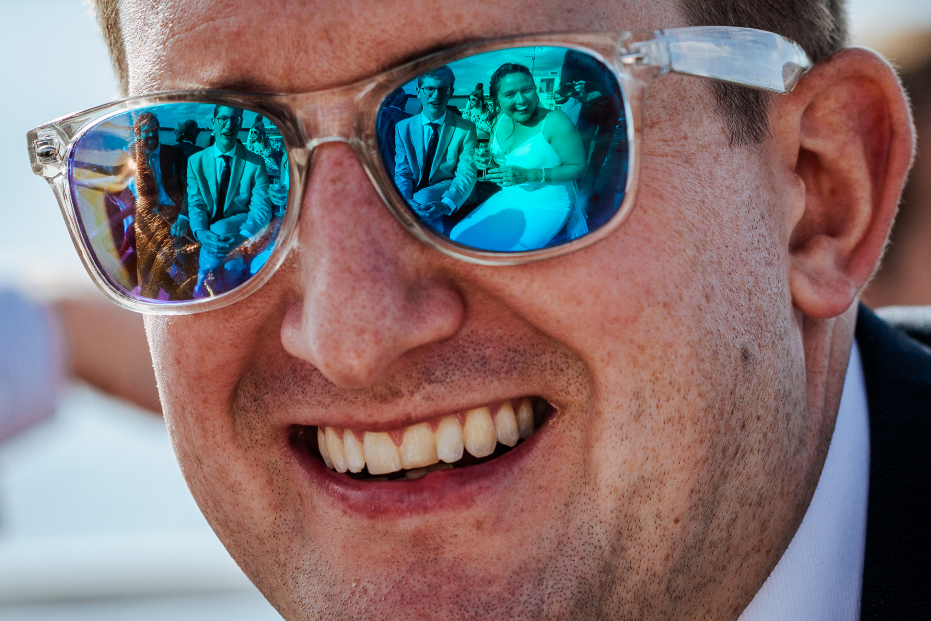 Bride's reflection seen in sunglasses of wedding guest on Rutland Belle, Rutland, creating joy.