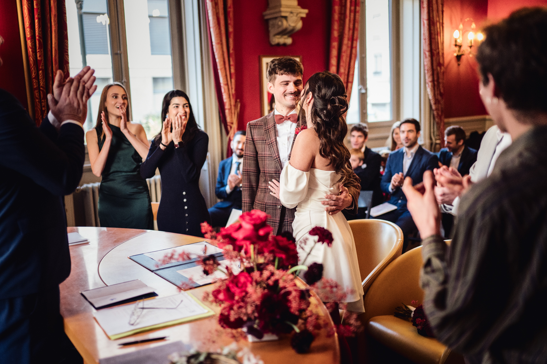 Couple joyfully says “yes” in Lyon’s city hall, surrounded by smiling friends and family.