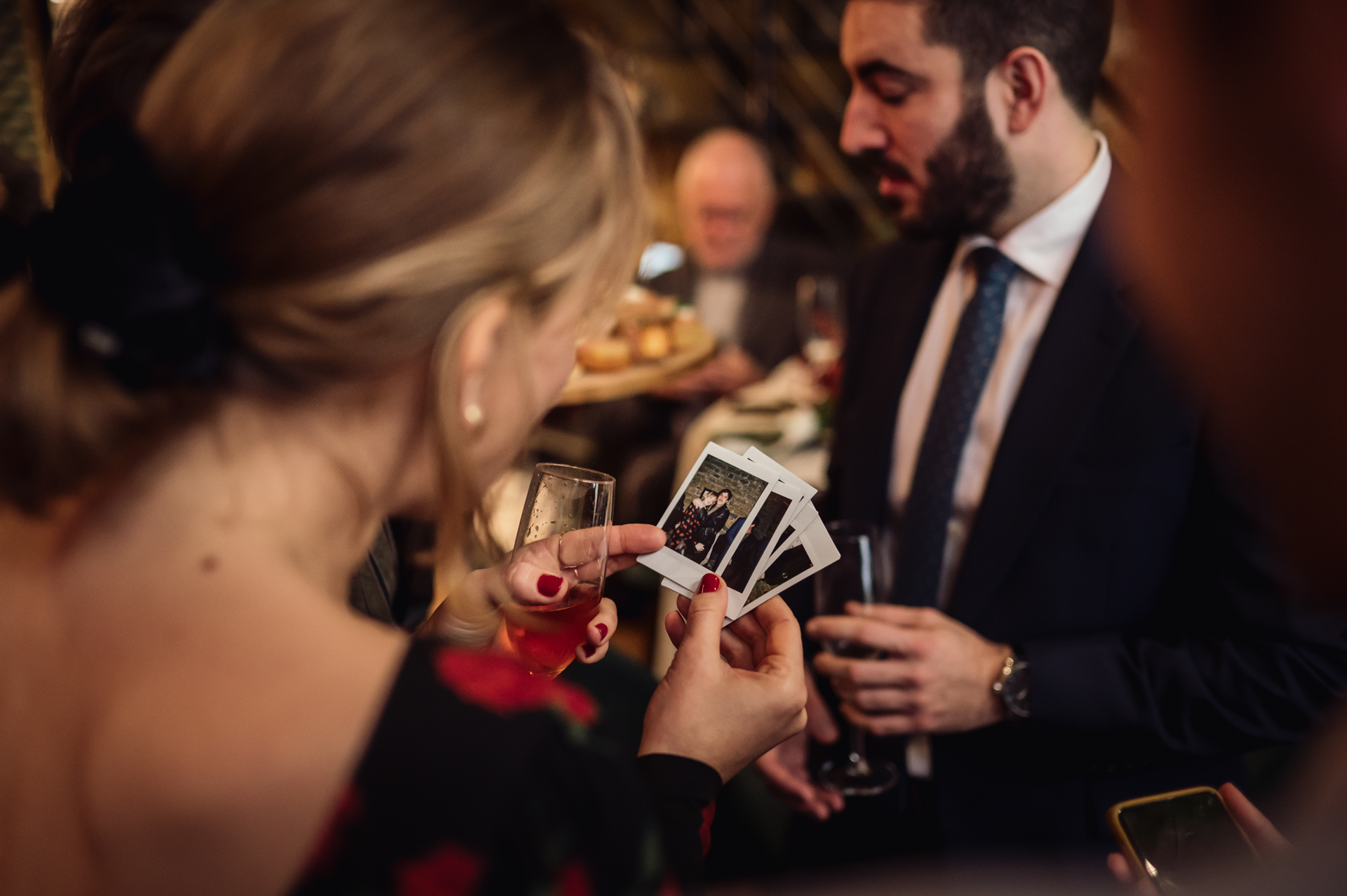 Captured from behind, a guest in Lyon flips through instant photos, evoking instant nostalgia.