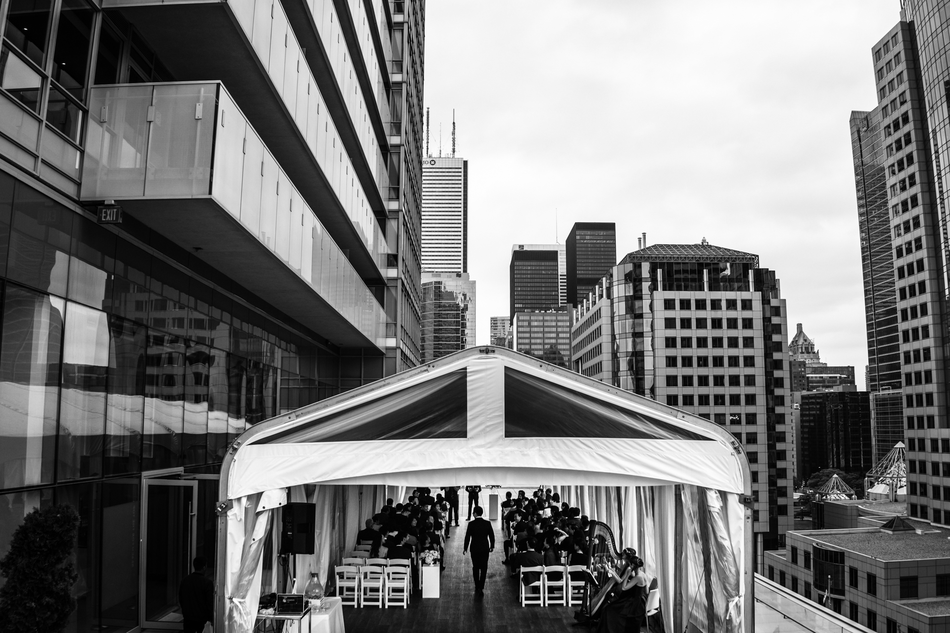 Urban, city tent over the groom wakling into the ceremony location - Tent wedding photography